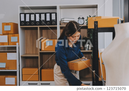 Asian SME business women use laptop computer checking customer order online shipping boxes at home. Starting Small business entrepreneur SME freelance. Online business, Work at home concept. Asian SME business women use laptop computer checking customer order online shipping boxes at home. Starting Small business entrepreneur SME freelance. Online business, Work at home concept. 123715070