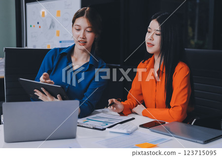 Entrepreneur Asian businessman and businesswoman discussing new business project in tablet in modern Meeting In Modern Office, Asian business casual concept. 123715095