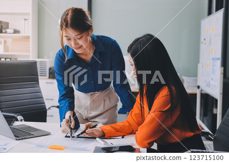 Entrepreneur Asian businessman and businesswoman discussing new business project in tablet in modern Meeting In Modern Office, Asian business casual concept. 123715100