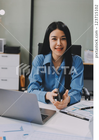 Entrepreneur Asian businessman and businesswoman discussing new business project in tablet in modern Meeting In Modern Office, Asian business casual concept. 123715102
