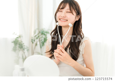 Asian woman massaging with facial roller 123715574