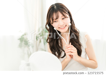 Asian woman massaging with facial roller Asian woman massaging with facial roller 123715575