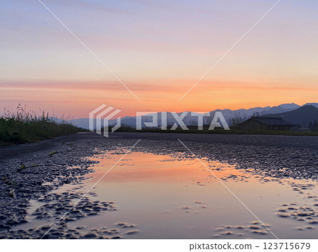 Magic hour on a bank road with puddles after the rain 123715679