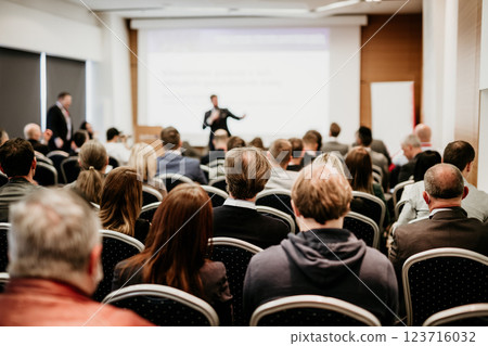 Speaker giving a talk in conference hall at business event. Rear view of unrecognizable people in audience at the conference hall. Business and entrepreneurship concept 123716032