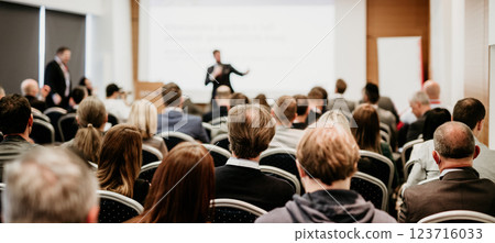 Speaker giving a talk in conference hall at business event. Rear view of unrecognizable people in audience at the conference hall. Business and entrepreneurship concept Speaker giving a talk in conference hall at business event. Rear view of unrecognizable people in audience at the conference hall. Business and entrepreneurship concept 123716033