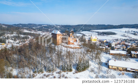 Pecka castle stands majestically amid a winter landscape, blanketed in snow. The surrounding village and hills create a picturesque setting, showcasing the beauty of Czechia in the cold season. 123716188