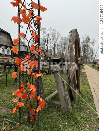 Rustic wooden cartwheel with autumn decorations in village setting 123716465