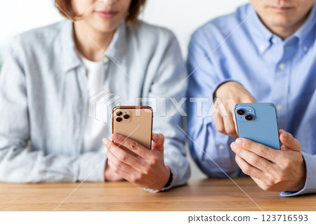 一對中年夫妻在家看智慧型手機 123716593