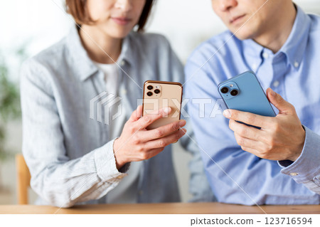 一對中年夫妻在家看智慧型手機 123716594