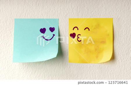 Couple in Love Concept. Two Sticky Notes on the white Wall with Cute Hand Drawn Emoticon Face as means of Love Couple in Love Concept. Two Sticky Notes on the white Wall with Cute Hand Drawn Emoticon Face as means of Love 123716641