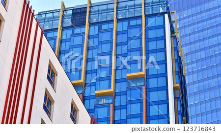 View of an modern apartment building standing next to a new modern office building with a glass facade. View of an modern apartment building standing next to a new modern office building with a glass facade. 123716843