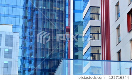 View of an modern apartment building standing next to a new modern office building with a glass facade. 123716844