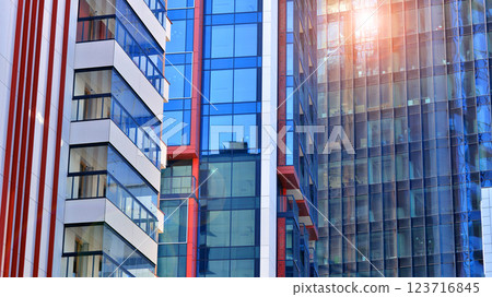 View of an modern apartment building standing next to a new modern office building with a glass facade. View of an modern apartment building standing next to a new modern office building with a glass facade. 123716845
