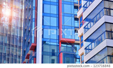View of an modern apartment building standing next to a new modern office building with a glass facade. View of an modern apartment building standing next to a new modern office building with a glass facade. 123716848