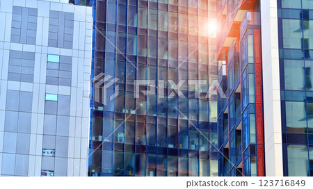 View of an modern apartment building standing next to a new modern office building with a glass facade. 123716849