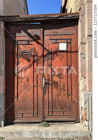 Old rusty metal door of a building 123717304