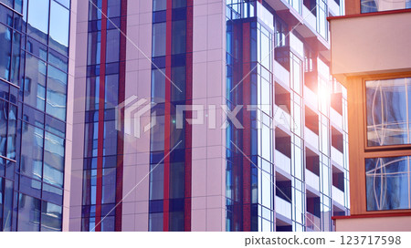 View of an modern apartment building standing next to a new modern office building with a glass facade. 123717598