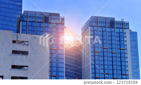 View of an modern apartment building standing next to a new modern office building with a glass facade. 123718104