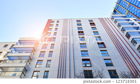 View of an modern apartment building standing next to a new modern office building with a glass facade. 123718301