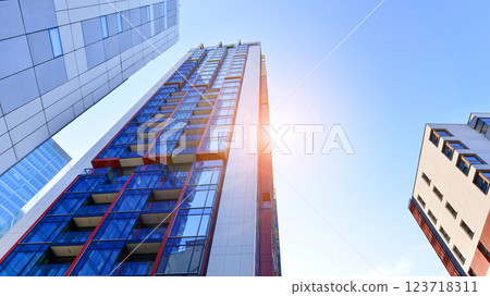 View of an modern apartment building standing next to a new modern office building with a glass facade. 123718311