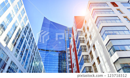 View of an modern apartment building standing next to a new modern office building with a glass facade. 123718312