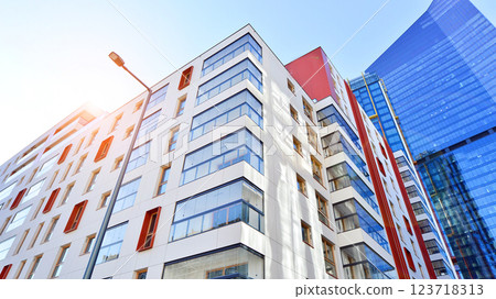 View of an modern apartment building standing next to a new modern office building with a glass facade. 123718313