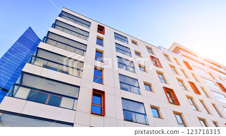 View of an modern apartment building standing next to a new modern office building with a glass facade. View of an modern apartment building standing next to a new modern office building with a glass facade. 123718315