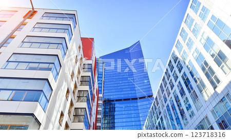 View of an modern apartment building standing next to a new modern office building with a glass facade. 123718316