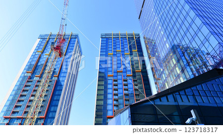 View of an modern apartment building standing next to a new modern office building with a glass facade. 123718317