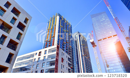 View of an modern apartment building standing next to a new modern office building with a glass facade. 123718320