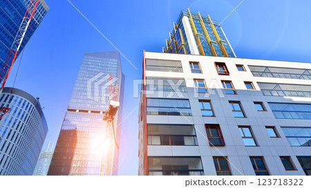 View of an modern apartment building standing next to a new modern office building with a glass facade. 123718322