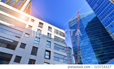 View of an modern apartment building standing next to a new modern office building with a glass facade. View of an modern apartment building standing next to a new modern office building with a glass facade. 123718327
