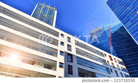 View of an modern apartment building standing next to a new modern office building with a glass facade. 123718330