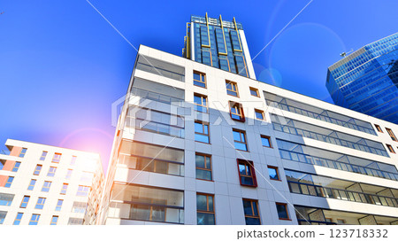 View of an modern apartment building standing next to a new modern office building with a glass facade. 123718332