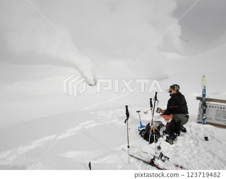 Telemark skier drinking coffee in front of a fumarole in Mount Daisetsu Telemark skier drinking coffee in front of a fumarole in Mount Daisetsu 123719482