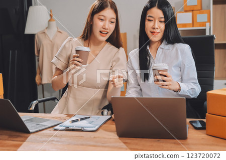 Startup SME small business entrepreneur of freelance Asian woman using a laptop with box Cheerful success Asian woman her hand lifts up online marketing packaging box and delivery SME idea concept 123720072