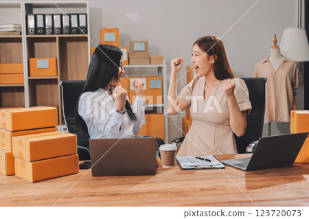 Startup SME small business entrepreneur of freelance Asian woman using a laptop with box Cheerful success Asian woman her hand lifts up online marketing packaging box and delivery SME idea concept 123720073