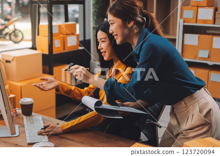 Asian SME business women use laptop computer checking customer order online shipping boxes at home. Starting Small business entrepreneur SME freelance. Online business, Work at home concept. Asian SME business women use laptop computer checking customer order online shipping boxes at home. Starting Small business entrepreneur SME freelance. Online business, Work at home concept. 123720094