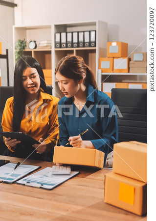 Asian SME business women use laptop computer checking customer order online shipping boxes at home. Starting Small business entrepreneur SME freelance. Online business, Work at home concept. 123720097