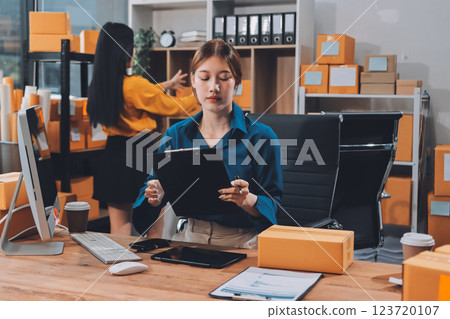 Asian SME business women use laptop computer checking customer order online shipping boxes at home. Starting Small business entrepreneur SME freelance. Online business, Work at home concept. 123720107