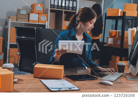Asian SME business women use laptop computer checking customer order online shipping boxes at home. Starting Small business entrepreneur SME freelance. Online business, Work at home concept. Asian SME business women use laptop computer checking customer order online shipping boxes at home. Starting Small business entrepreneur SME freelance. Online business, Work at home concept. 123720108