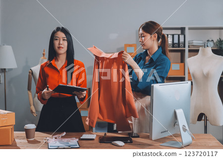 Fashion blogger concept, Young Asian women selling clothes on video streaming.Startup small business SME, using smartphone or tablet taking receive and checking in office Fashion blogger concept, Young Asian women selling clothes on video streaming.Startup small business SME, using smartphone or tablet taking receive and checking in office 123720117