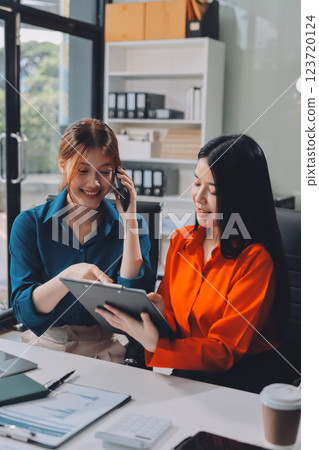 Entrepreneur Asian businessman and businesswoman discussing new business project in tablet in modern Meeting In Modern Office, Asian business casual concept. 123720124