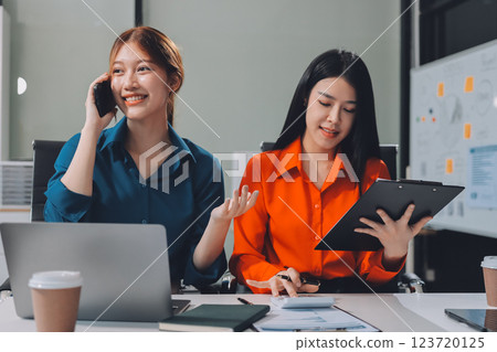 Entrepreneur Asian businessman and businesswoman discussing new business project in tablet in modern Meeting In Modern Office, Asian business casual concept. 123720125