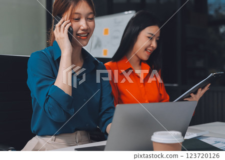 Entrepreneur Asian businessman and businesswoman discussing new business project in tablet in modern Meeting In Modern Office, Asian business casual concept. 123720126