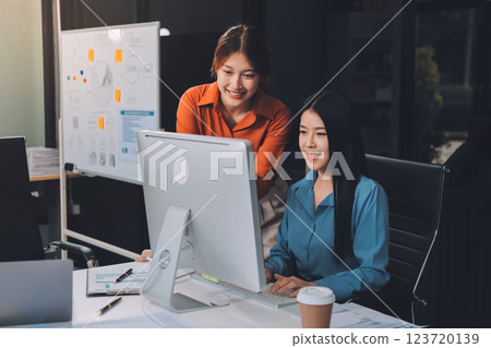 Entrepreneur Asian businessman and businesswoman discussing new business project in tablet in modern Meeting In Modern Office, Asian business casual concept. 123720139