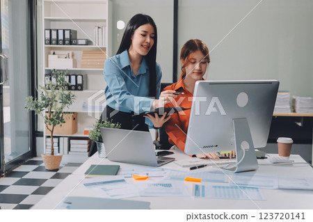 Entrepreneur Asian businessman and businesswoman discussing new business project in tablet in modern Meeting In Modern Office, Asian business casual concept. 123720141