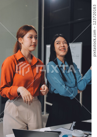 Portrait happy two young asian businesswoman standing with confident together in office, happiness two business woman arms crossed with success, coworker and friendship, business and team. Portrait happy two young asian businesswoman standing with confident together in office, happiness two business woman arms crossed with success, coworker and friendship, business and team. 123720163