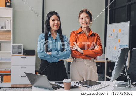 Portrait happy two young asian businesswoman standing with confident together in office, happiness two business woman arms crossed with success, coworker and friendship, business and team. Portrait happy two young asian businesswoman standing with confident together in office, happiness two business woman arms crossed with success, coworker and friendship, business and team. 123720165