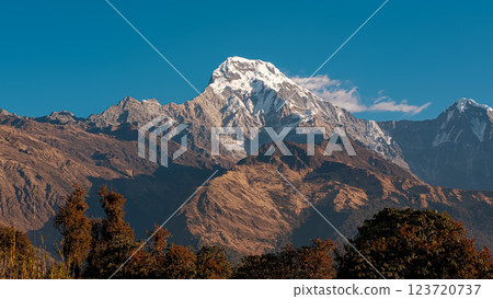 Annapurna South majestic peak under morning sunlight with blue sky Annapurna South majestic peak under morning sunlight with blue sky 123720737